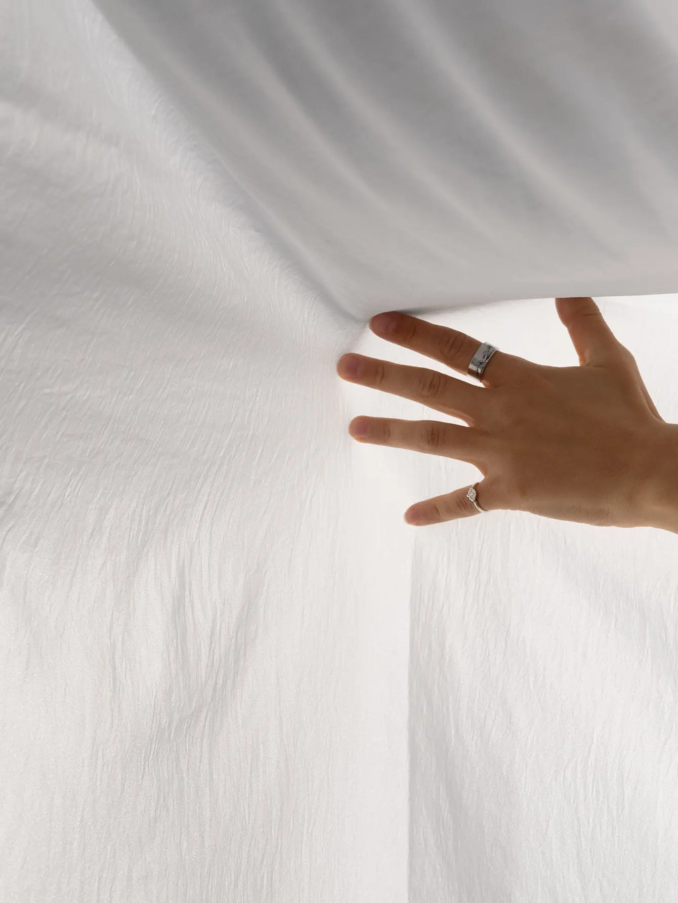 sábanas algodón con una mano sosteniendola