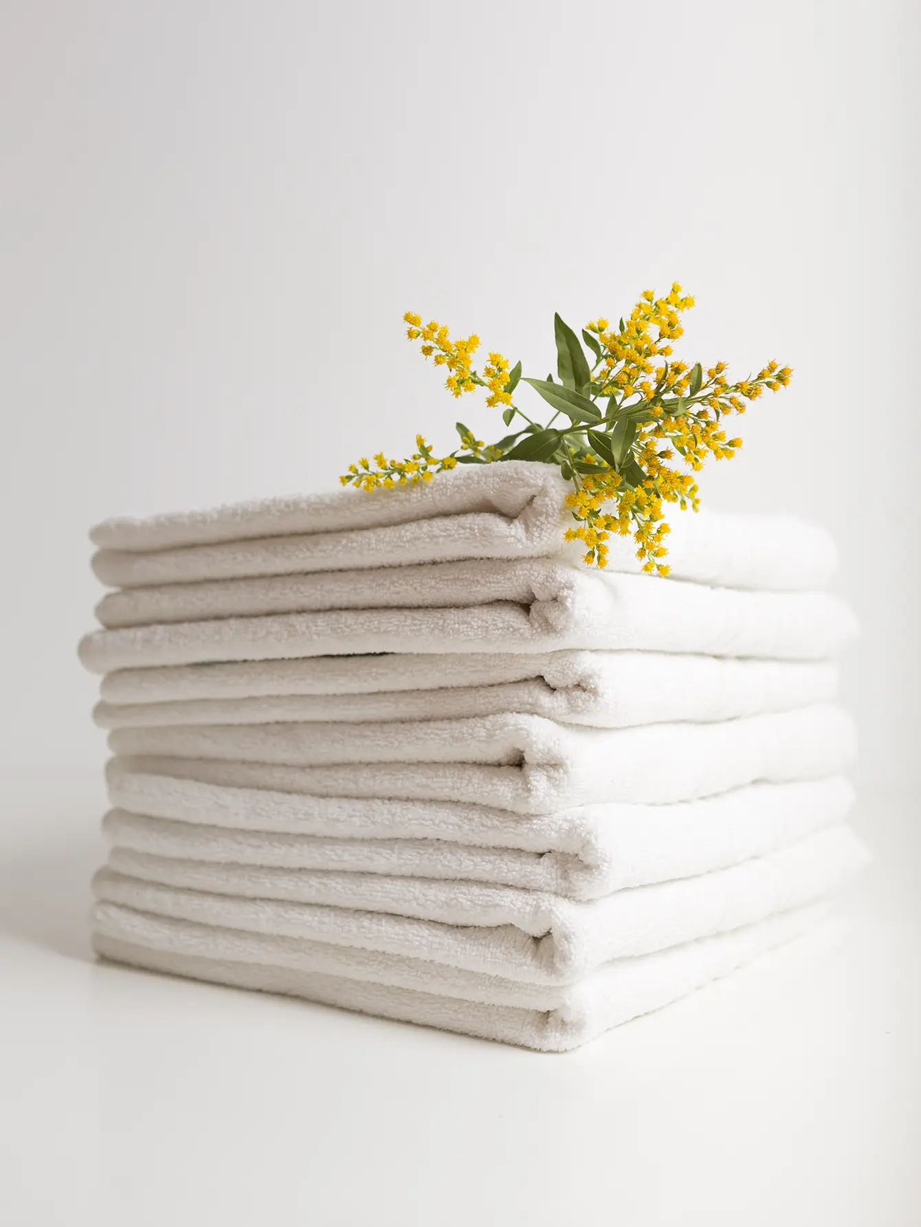 Pila de toallas con una flor amarilla